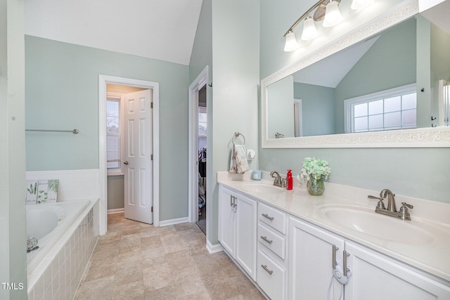 full bath featuring a bath, double vanity, lofted ceiling, and a sink