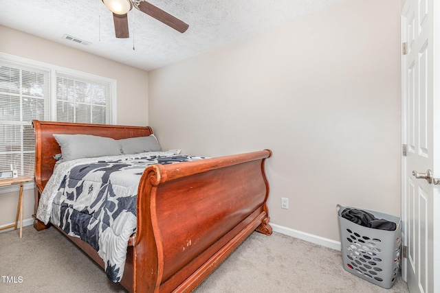 bedroom featuring visible vents, baseboards, carpet, a textured ceiling, and a ceiling fan