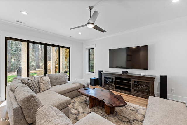 living room with visible vents, wood finished floors, a healthy amount of sunlight, and ornamental molding