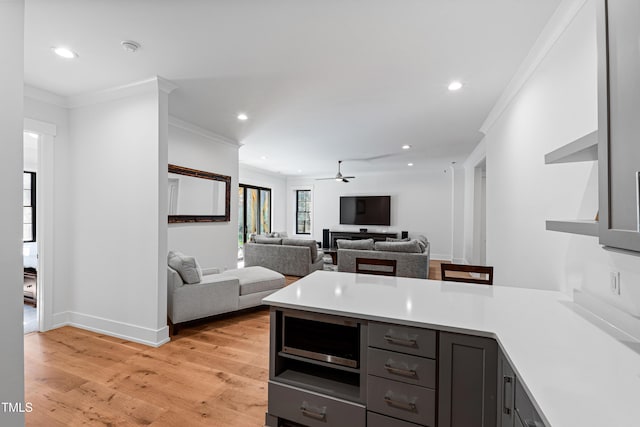 kitchen with a peninsula, recessed lighting, light countertops, and light wood-type flooring