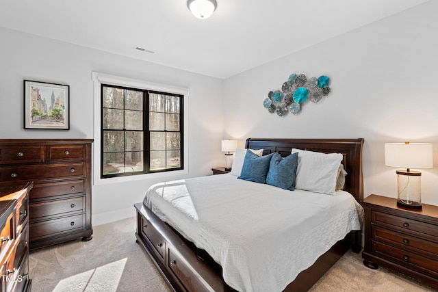 bedroom featuring baseboards, visible vents, and light carpet