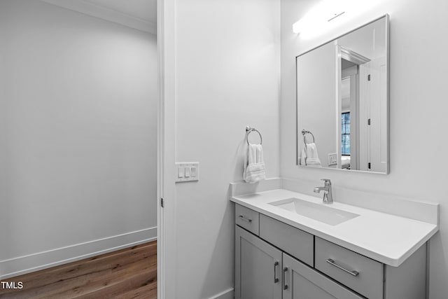 bathroom with vanity, wood finished floors, and baseboards