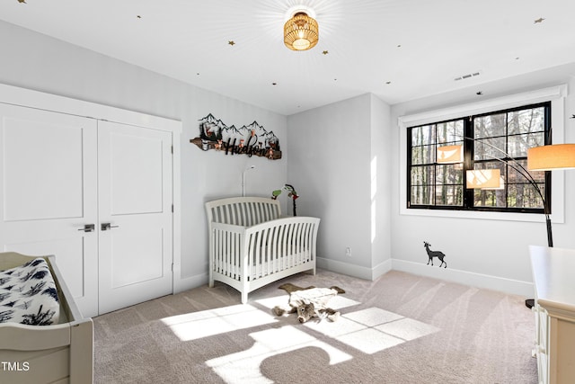 bedroom with a nursery area, visible vents, baseboards, and light colored carpet