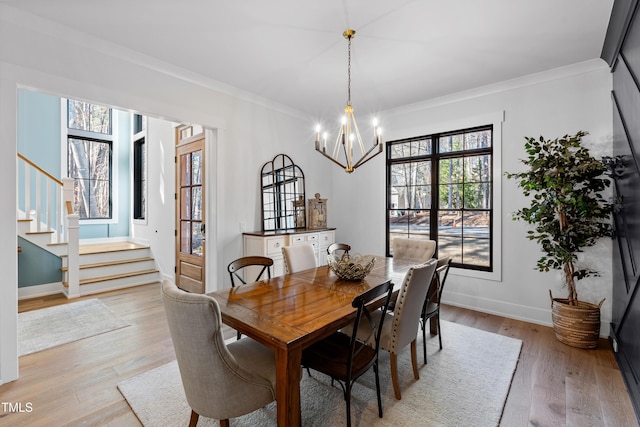 dining area featuring stairway, light wood-style floors, a chandelier, and crown molding