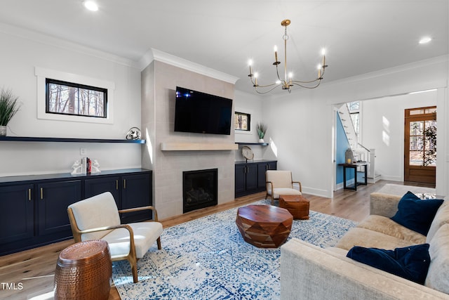 living area with crown molding, recessed lighting, a fireplace, and light wood-type flooring