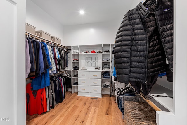 walk in closet with light wood-style floors