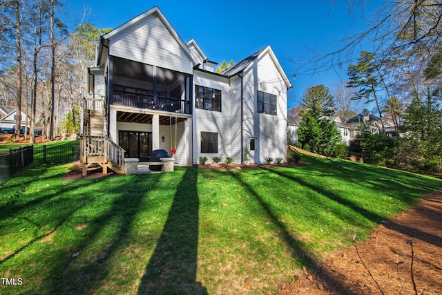 back of house featuring a lawn, fence, stairway, a sunroom, and a patio area