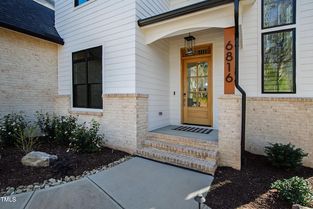 doorway to property with brick siding