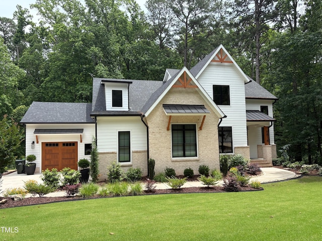 6816 Rainwater Rd, Raleigh, NC 27615 - modern inspired farmhouse featuring a garage, a front yard, brick siding, and roof with shingles