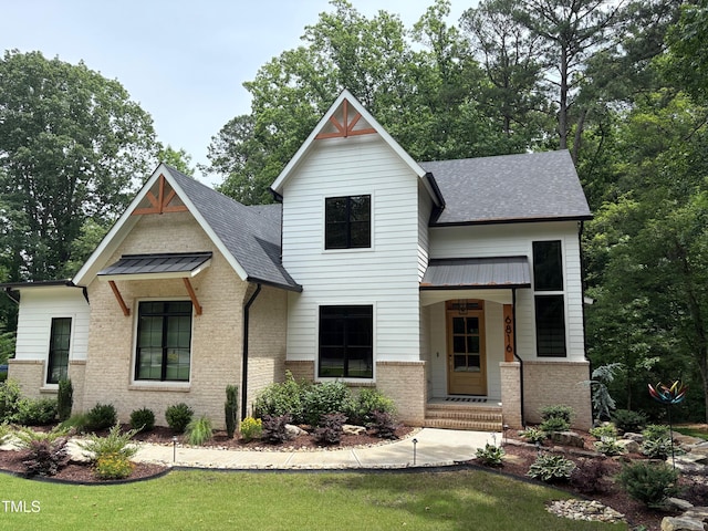 6816 Rainwater Rd, Raleigh, NC 27615 - modern farmhouse with a shingled roof, brick siding, and a front yard