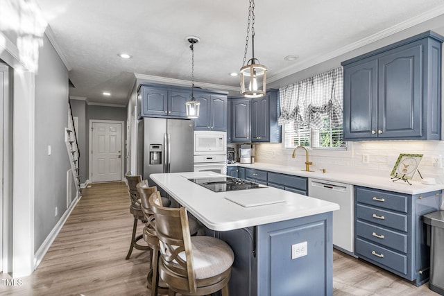 kitchen with tasteful backsplash, a kitchen bar, white appliances, blue cabinets, and a sink