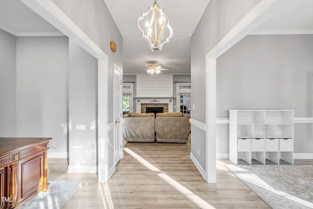 hallway with ornamental molding, baseboards, an inviting chandelier, and wood finished floors