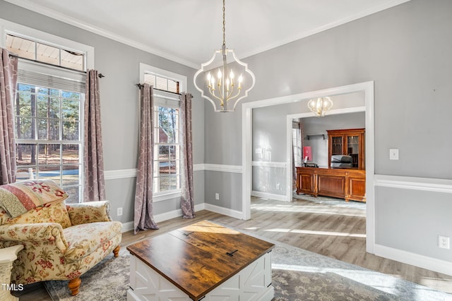 sitting room featuring light wood-style flooring, ornamental molding, baseboards, and a chandelier