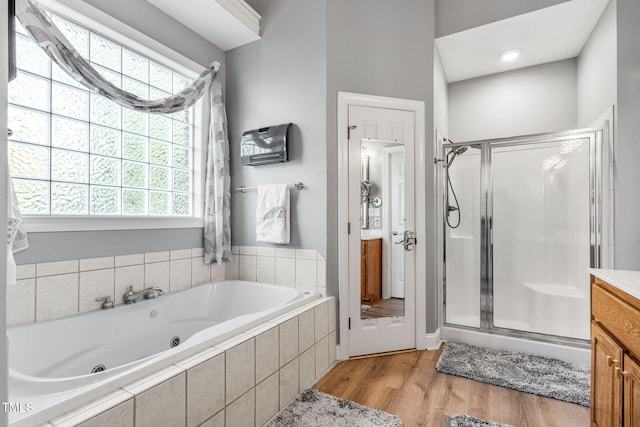 full bathroom featuring plenty of natural light, a whirlpool tub, and a shower stall