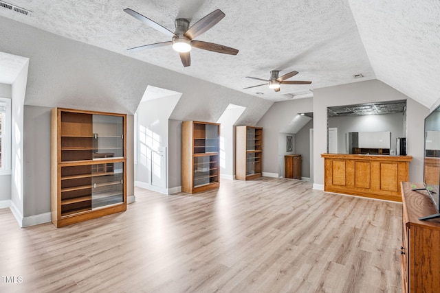 additional living space featuring vaulted ceiling, light wood-style floors, visible vents, and ceiling fan