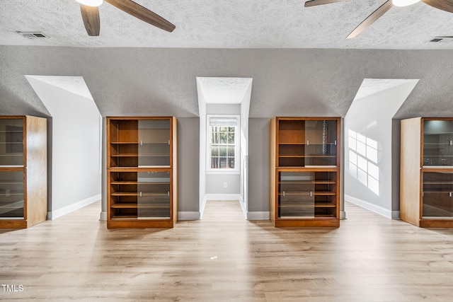 unfurnished living room with visible vents, wood finished floors, and a ceiling fan