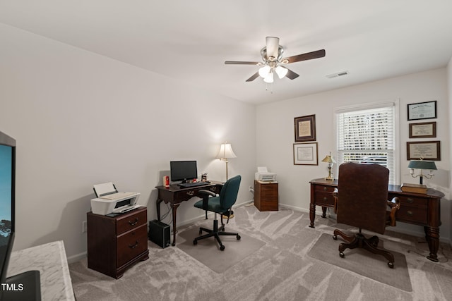 home office with visible vents, baseboards, light colored carpet, and ceiling fan