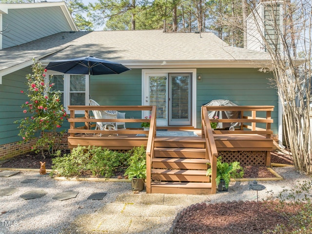 rear view of house featuring a wooden deck and a shingled roof