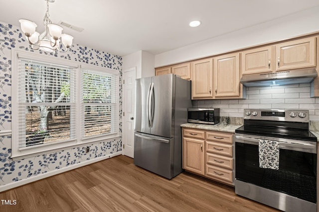 kitchen featuring visible vents, light brown cabinets, under cabinet range hood, light wood-style flooring, and stainless steel appliances