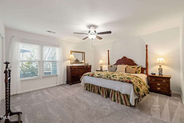 bedroom featuring visible vents, light colored carpet, baseboards, and ceiling fan