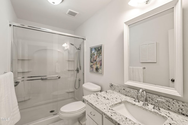 full bath with vanity, a shower stall, toilet, and visible vents