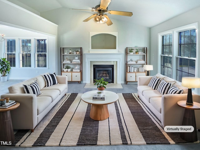 living room featuring a glass covered fireplace, ceiling fan, and vaulted ceiling