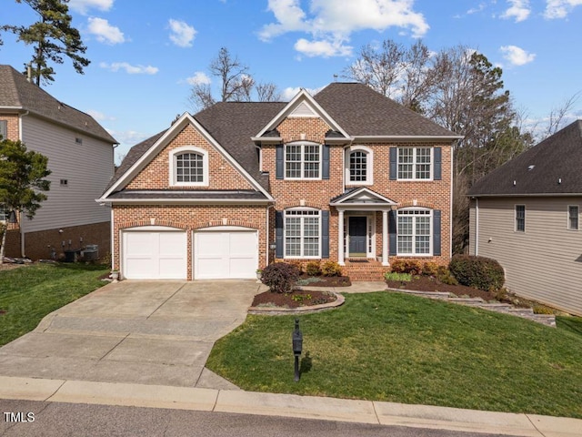 colonial inspired home with brick siding, driveway, and a front yard