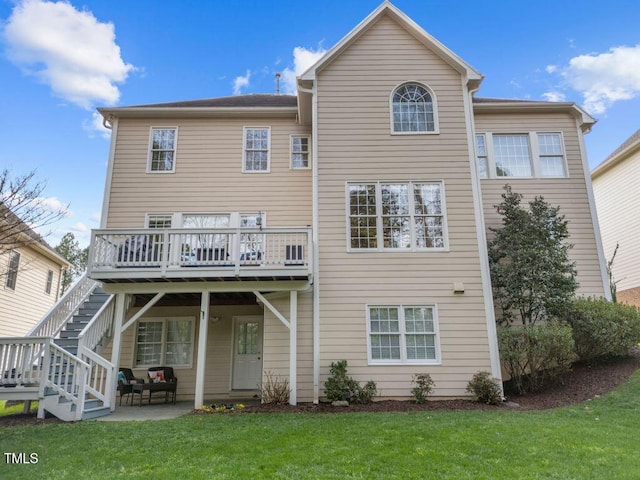 rear view of house featuring a deck, a patio area, stairway, and a lawn