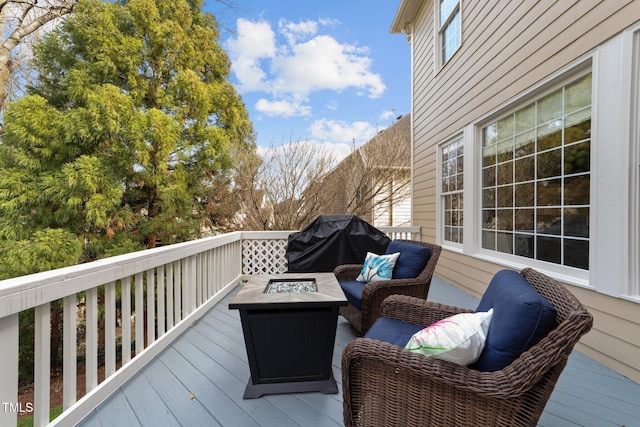 wooden terrace with an outdoor living space with a fire pit