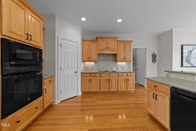 kitchen with light brown cabinets, black appliances, light wood-type flooring, and light countertops