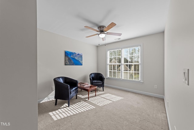 living area with visible vents, baseboards, carpet, and a ceiling fan