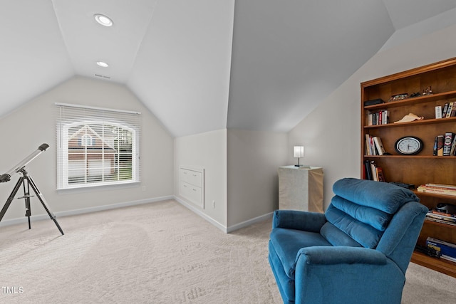 living area featuring visible vents, baseboards, lofted ceiling, and light carpet