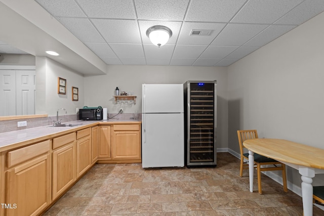 kitchen featuring visible vents, freestanding refrigerator, a sink, light countertops, and black microwave