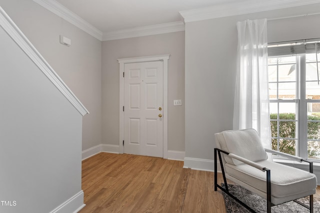 entryway with crown molding, light wood-style flooring, a healthy amount of sunlight, and baseboards