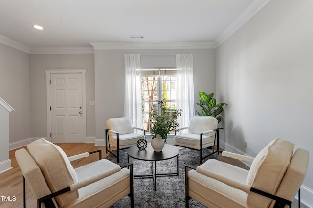 sitting room with wood finished floors, visible vents, and baseboards