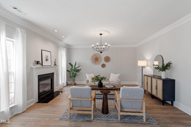 living room with plenty of natural light, an inviting chandelier, visible vents, and wood finished floors