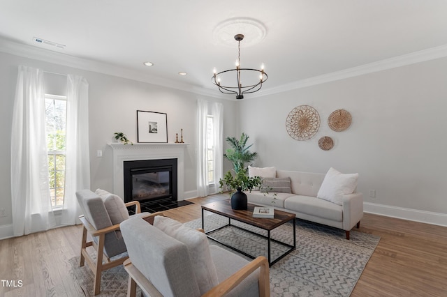 living room featuring visible vents, a chandelier, crown molding, and light wood finished floors