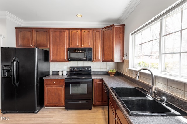 kitchen featuring dark countertops, black appliances, tasteful backsplash, and a sink