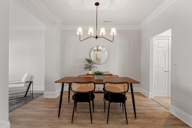 dining area featuring crown molding, light wood-style flooring, baseboards, and visible vents