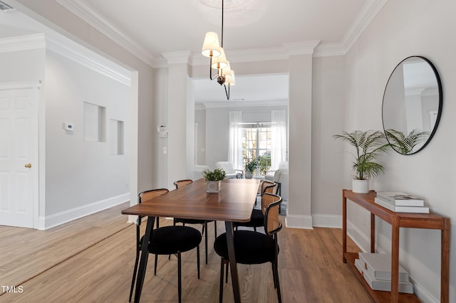 dining room with light wood finished floors, baseboards, and ornamental molding