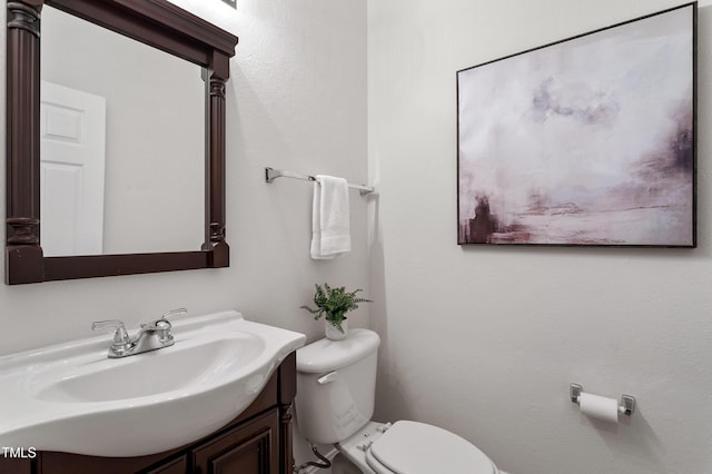 half bathroom with vanity and toilet