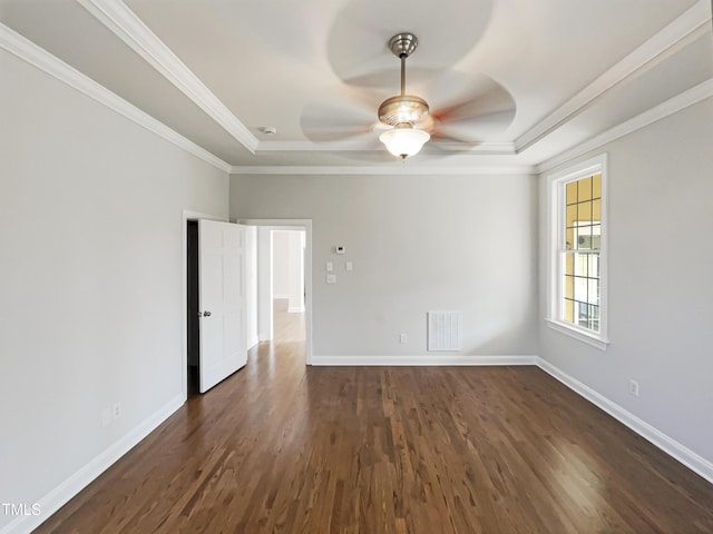 empty room featuring visible vents, baseboards, dark wood-style flooring, and crown molding