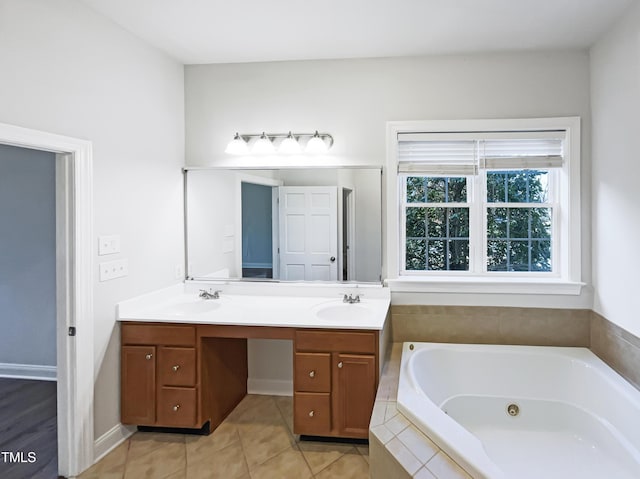 bathroom featuring a sink, a jetted tub, double vanity, and tile patterned floors