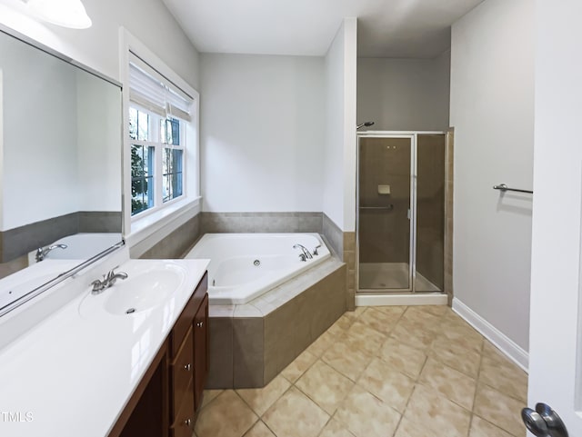 bathroom with tile patterned floors, baseboards, a stall shower, a bath, and vanity