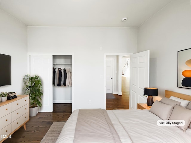 bedroom with dark wood finished floors and a closet