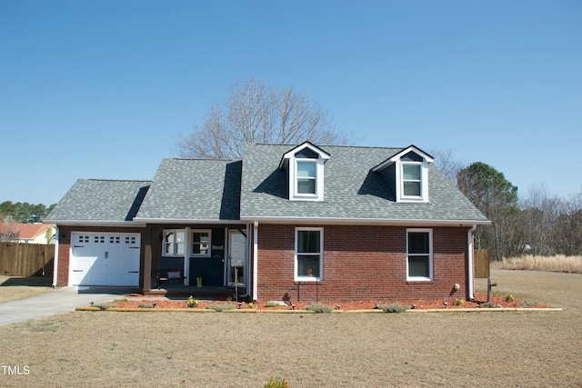 view of front of house featuring brick siding, roof with shingles, an attached garage, and fence