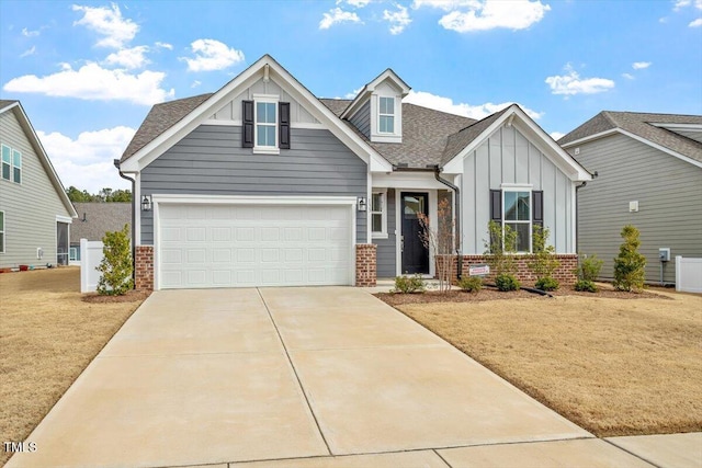 craftsman inspired home with driveway, board and batten siding, a front yard, a shingled roof, and brick siding