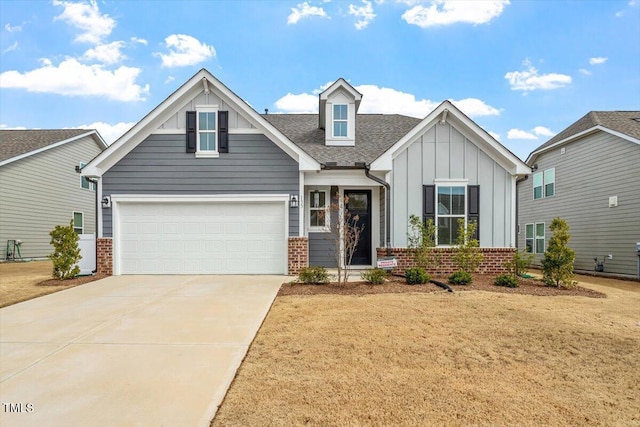 craftsman-style house with a shingled roof, concrete driveway, a garage, board and batten siding, and brick siding