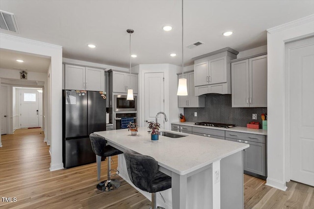 kitchen featuring a sink, visible vents, appliances with stainless steel finishes, and gray cabinetry