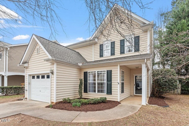 traditional-style house featuring concrete driveway, a garage, and roof with shingles